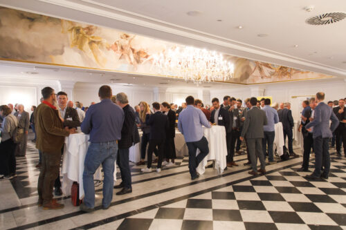 people standing around tables in a hall