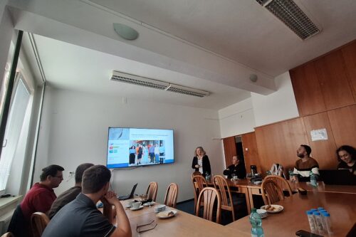 Ein Bildschirm und Personen in einem Konferenzraum