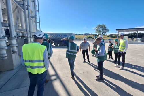 A group of people standing in front of a concrete mixer
